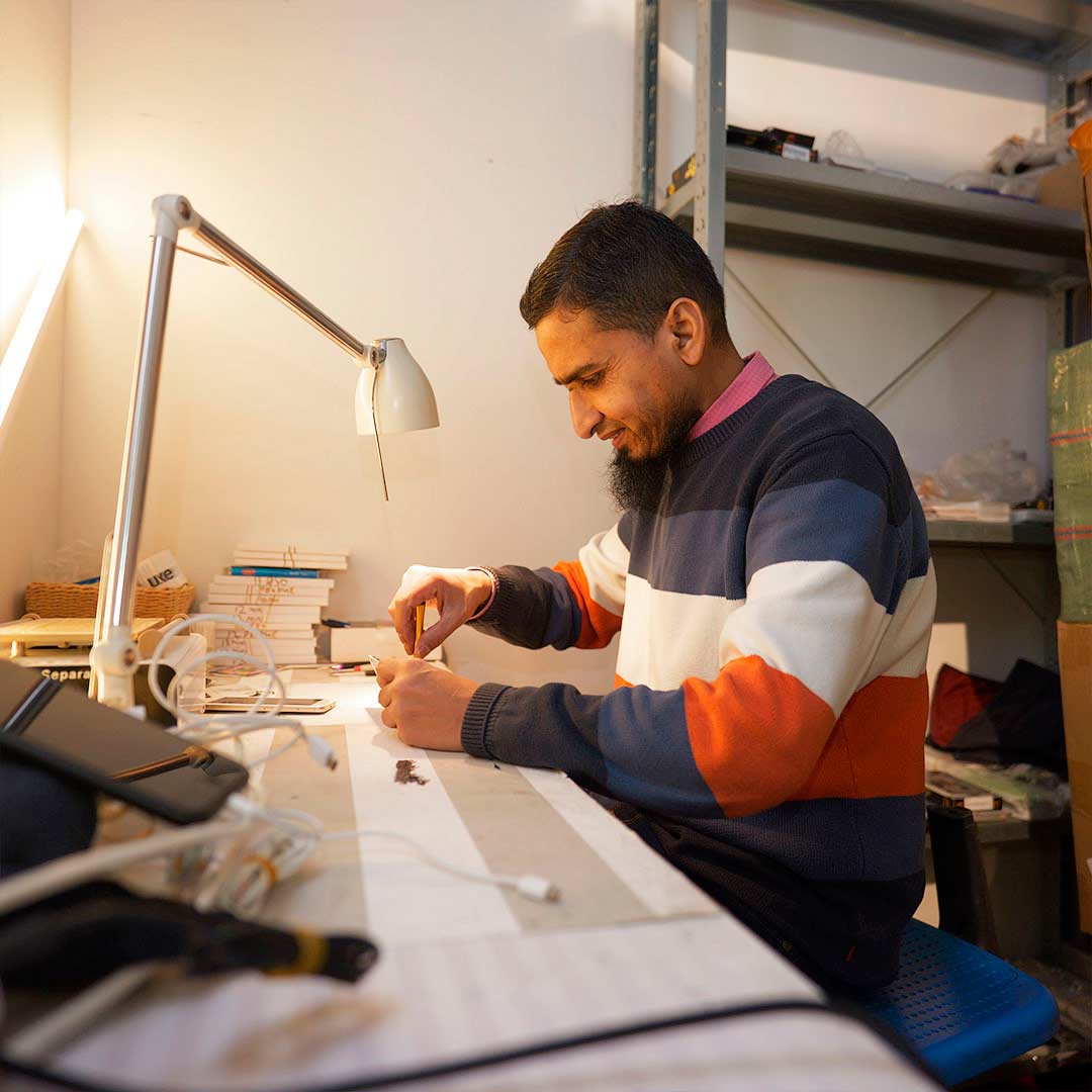 Mand som sidder og fixer telefon hos mobilmart glostrup